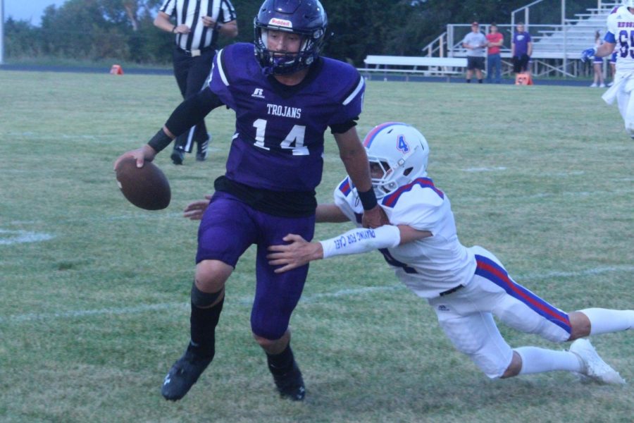 Quarterback Jaxson Gebhardt avoids a tackle from a Russell defender.
